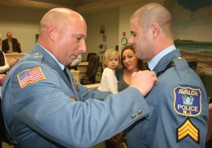Chief William McCormick places a badge on Sergeant Glassford